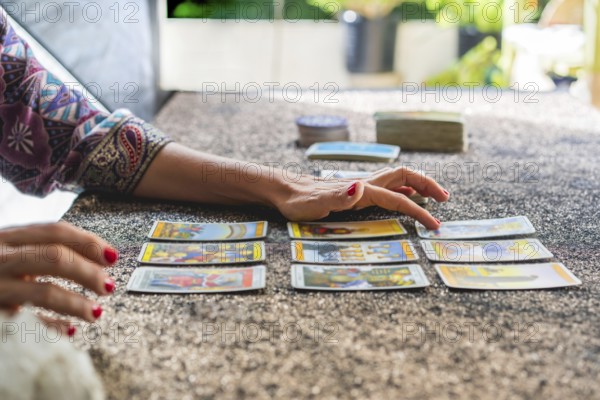Side view of a tarot reader's hands reading the cards