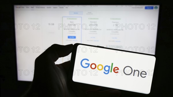 Stuttgart, Germany, 09-23-2023: Person holding mobile phone with logo of software subscription