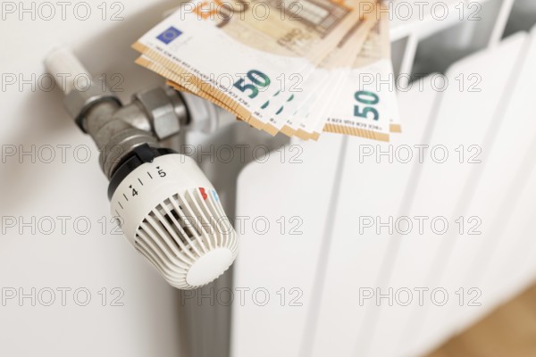Close up of Euro banknotes on a heating radiator. Energy cost crisis concept