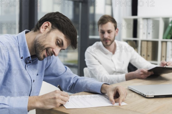 Side view smiley man signing work contract