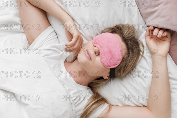 Woman wearing sleep mask her eyes top view