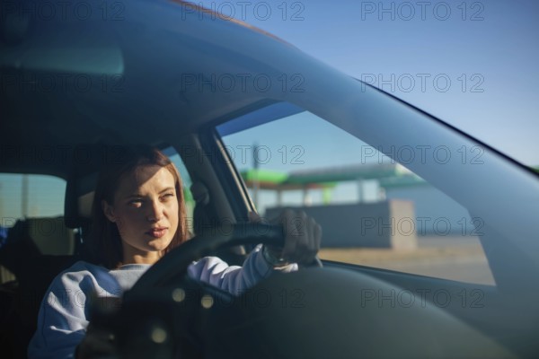 Young beautiful woman driver driving a car, happy trip, spring travel