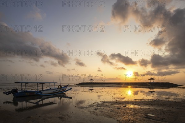 Morning landscape taken on the sandy beach. View over the sea to the horizon with small temples in