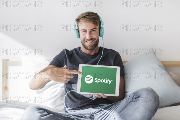 Young man holding tablet with spotify app