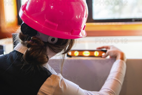 Construction quality control. close up rear view of a woman architect at work, she using a spirit