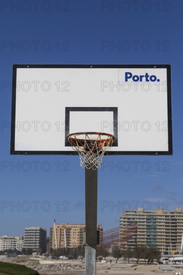 Basketball hoop in front of a blue sky with Porto lettering on the beach promenade in Matosinhos,