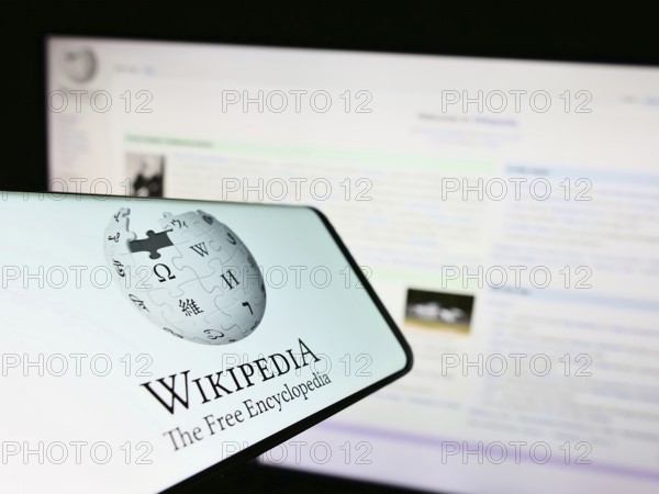 Stuttgart, Germany, 01-08-2023: Smartphone with logo of online encyclopedia Wikipedia on screen in