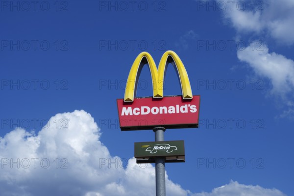 Mc Donalds logo in the blue sky with white clouds
