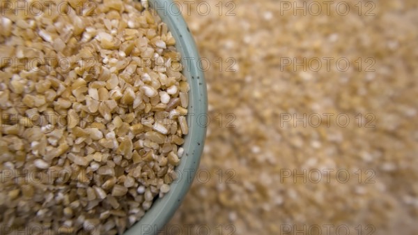 Cracked Broken Wheat Porridge (Dalia) in a Blue Bowl, Top View, Flat Lay, Closeup