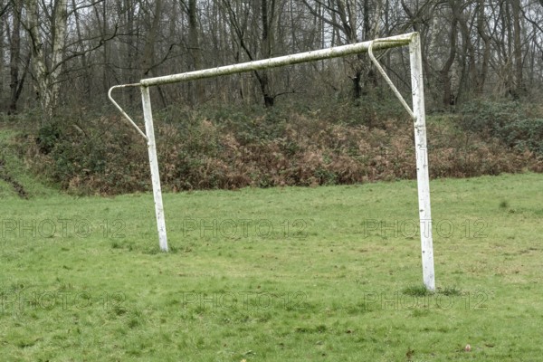 Poorly maintained soccer pitch with old soccer goal in the rain