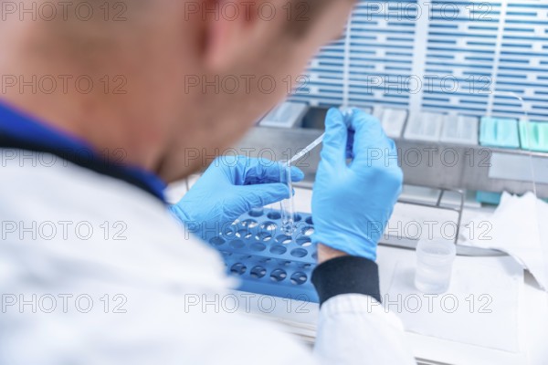 Doctor using pipette in a hospital laboratory to analyze samples