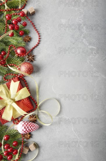 Flat lay view at Christmas decorations of gift box fir branch ribbon beads and glass balls on stone