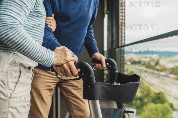 Close up unrecognizable senior couple holding hands while standing outside on the balcony