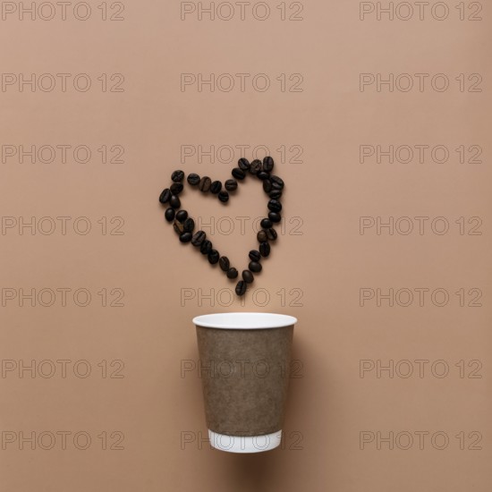 Beige background with paper coffee cup, coffee beans heart shape.