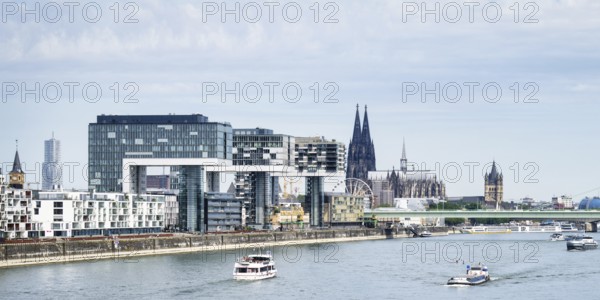 Excursion and cargo ships on the Rhine in front of the impressive panorama of Cologne with the
