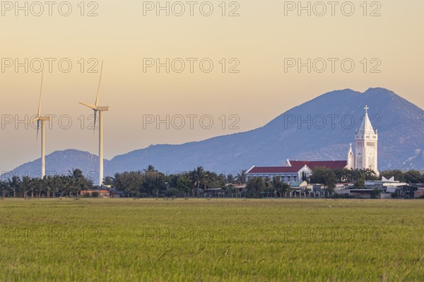 Landscape with rice fields and wind turbines and a Catholic church at Phan Rang, Ninh Thuan