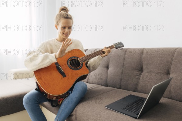 Young girl playing guitar home