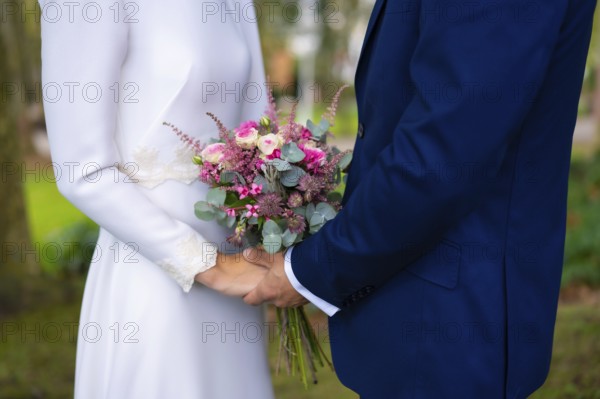 Detail of hands at the wedding of the happy bride and groom with flowers, marriage portraits