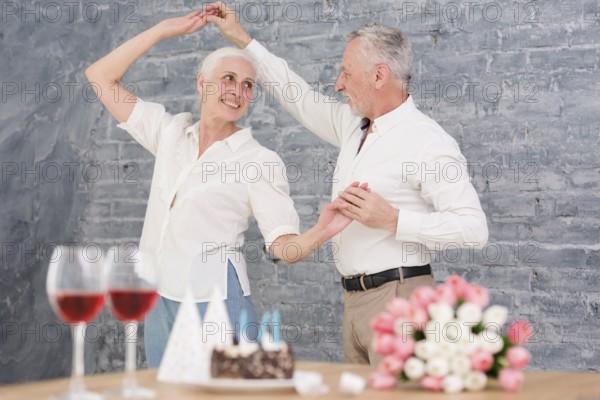 Senior husband wife dancing birthday party