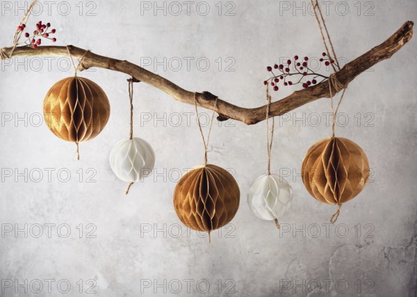 Handmade honeycomb balls hanging on a tree branch as a beautiful Christmas decoration. Scandinavian