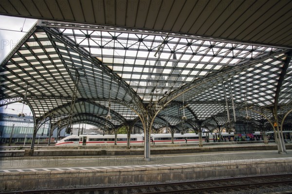 Cologne main railway station and high speed train in the distance (ICY) and people and glass