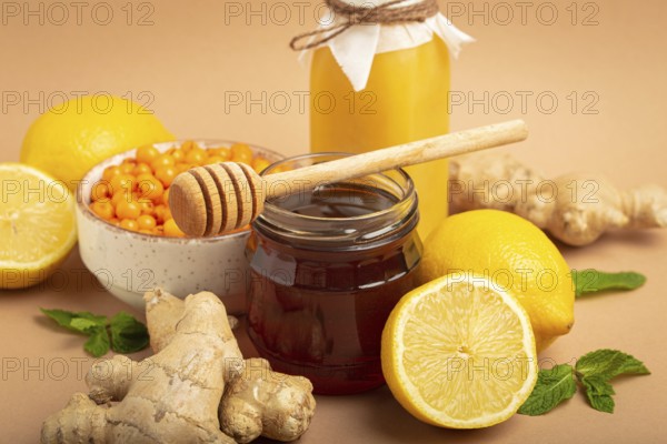 Composition with detox drink, sea buckthorn berries, lemons, mint, ginger, honey in glass jar. Food