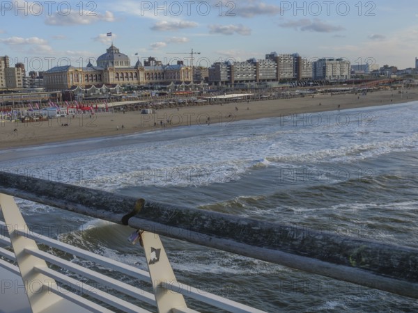 City on the beach with a view of the sea, pier and people along the coast, scheveningen, the