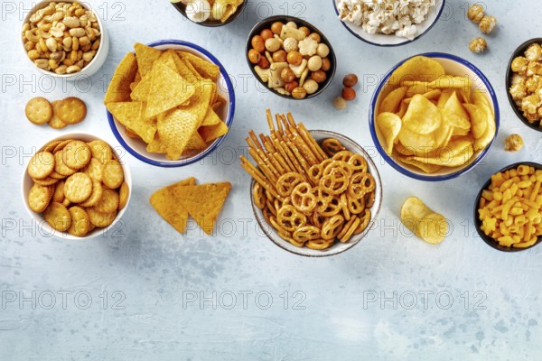 Salty snacks, party mix, overhead flat lay shot with copy space. An assortment of appetizers, shot