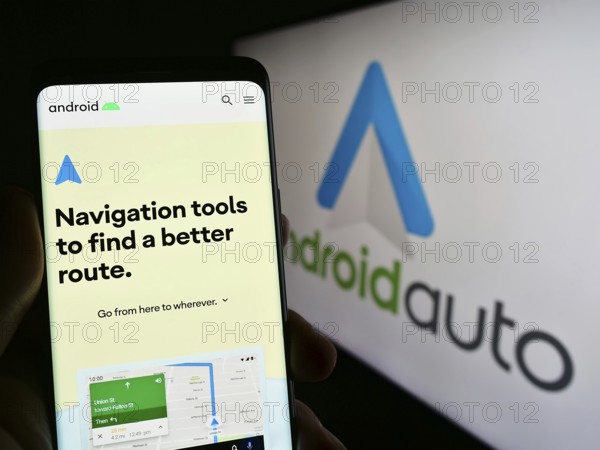 Stuttgart, Germany, 03-14-2023: Person holding smartphone with webpage of mobile app Android Auto
