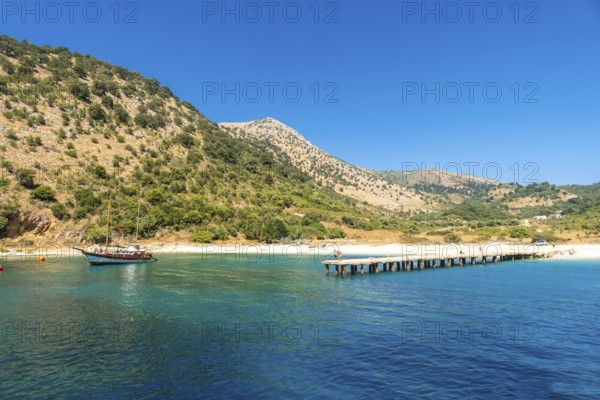 Boat pier at Kakome Beach seen from the boat on the Albanian riviera near Sarande and its turquoise