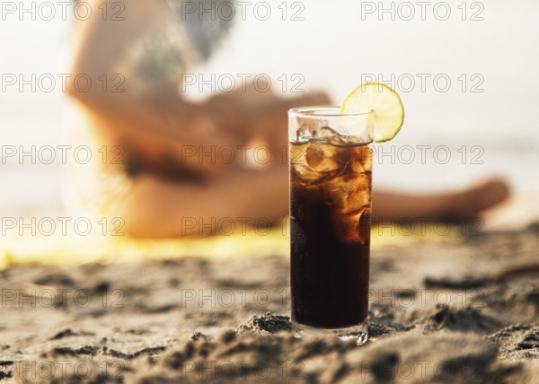 Glass coke with ice beach