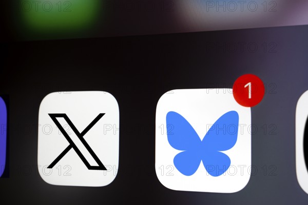 A close up of an iPhone screen displaying the X (twitter) app icon and the Bluesky app icon