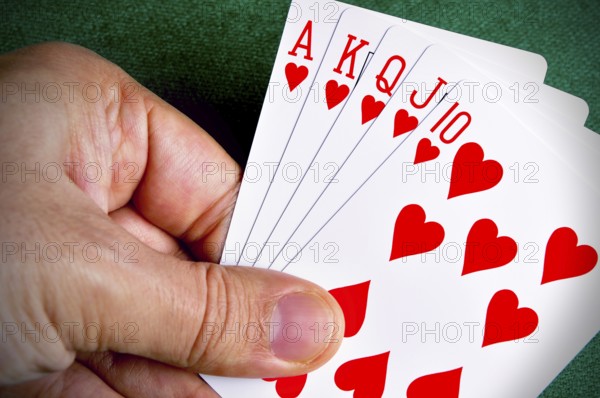 Hand holding a Royal Flush poker card sequence