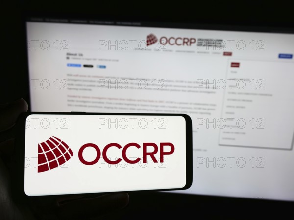 Stuttgart, Germany, 05-22-2024: Person holding smartphone with logo of Organized Crime and