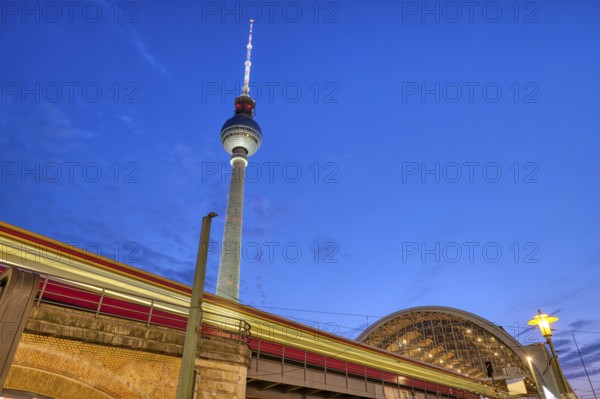 Local train entering Alexanderplatz station in Berlin at dusk