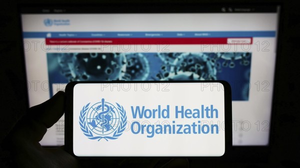 Stuttgart, Germany, 10-09-2022: Person holding smartphone with logo of UN agency World Health