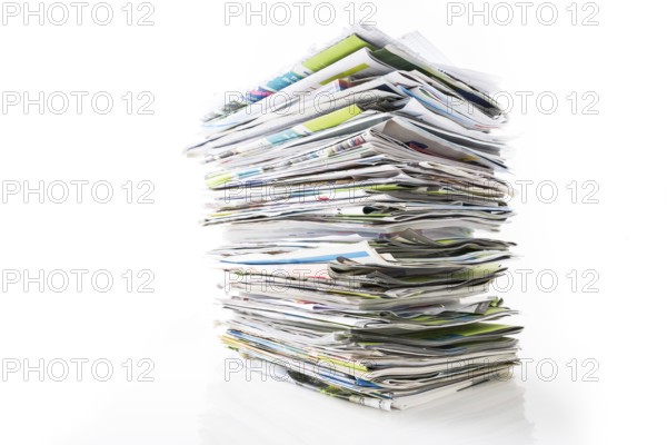 Stack of waste paper, old magazines, newspapers and leaflets for recycling isolated on white