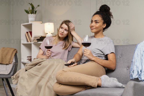 Women couch watching tv drinking wine