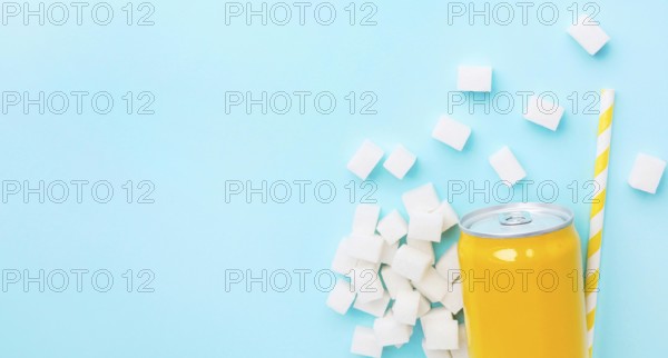 Flat lay soft drink can with sugar cubes straw