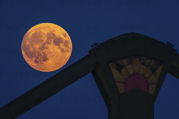 The full moon passes over the Flößerbrücke bridge in Frankfurt am Main. A super moon will shine