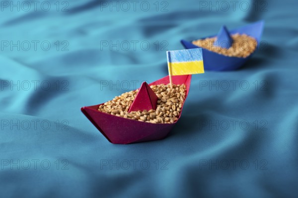 Ships with Ukrainian wheat grain made of paper concept