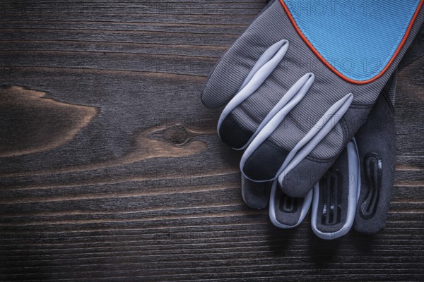 Pair of protective gardening gloves on wooden board agriculture concept