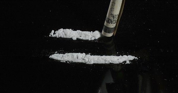 Dollar Bank notes and Powder Drug against Black Background
