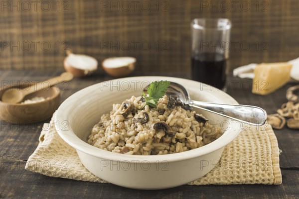 Close up mushroom risotto white bowl with spoon napkin table. Resolution and high quality beautiful