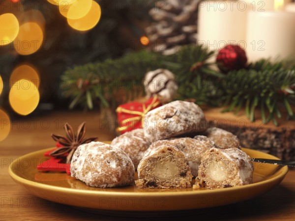 Delicious Christmas stollen on a ceramic plate in front of an Advent wreath and Christmas