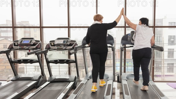 Women treadmill high five