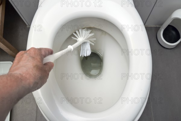 Hand is cleaning a disgusting dirty toilet with a brush, hygiene for health in the household, copy