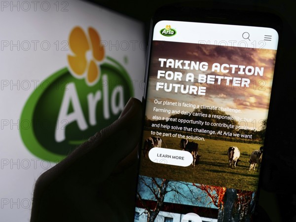 Stuttgart, Germany, 09-08-2023: Person holding cellphone with webpage of Nordic dairy company Arla