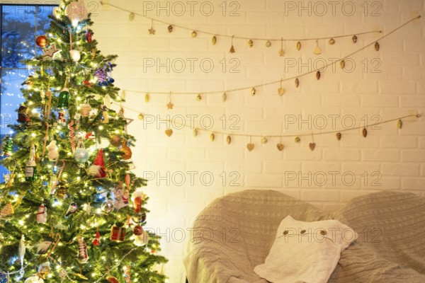 Christmas tree in white interior of a house with loft-style brick walls with garlands of glass toys