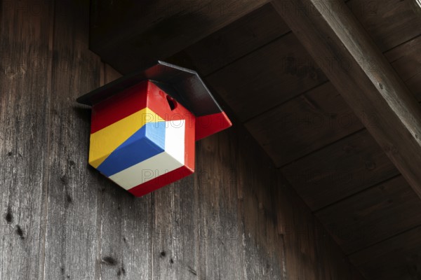 A nesting box for birds, songbirds, titmouse, sparrow, sparrow in the colours of the German and
